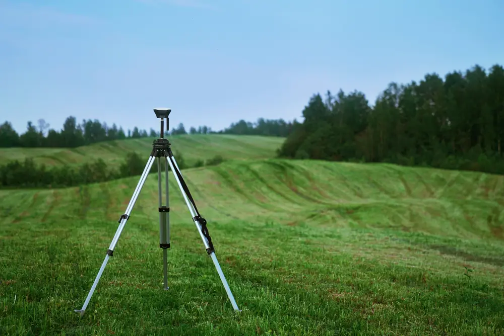 GNSS survey receiver on a pole in a field